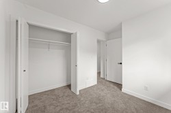 White walls with broad baseboards, textured carpeting, closet with bi-fold doors, and a flush mount ceiling light - 