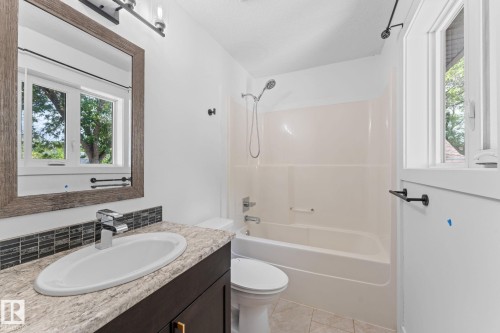 Vanity with a surface-mount sink, chrome faucet, and textured backsplash - 10825 93 Street Nw, Edmonton, AB - Indoor Photo Showing Bathroom