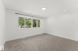 Neutral wall color, gray carpeting, multi-pane window, recessed lighting, and a flush-mount ceiling light - 