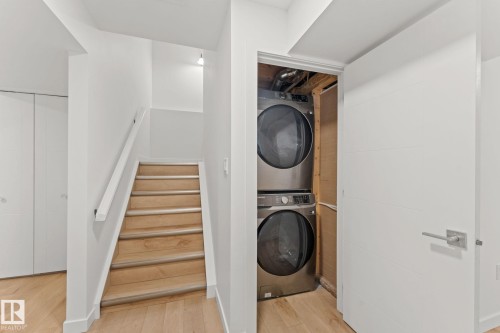 Integrated stacked laundry appliances - 10825 93 Street Nw, Edmonton, AB - Indoor Photo Showing Laundry Room