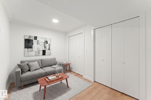 Recessed ceiling lighting, crown molding, and wood-finish flooring complement the white walls - 10825 93 Street Nw, Edmonton, AB - Indoor Photo Showing Living Room