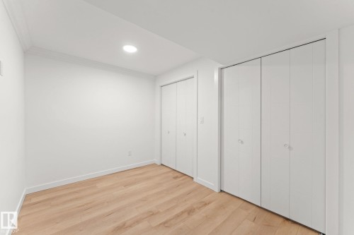 Recessed ceiling lighting, wood-finish flooring, and multiple bi-fold closets - 10825 93 Street Nw, Edmonton, AB - Indoor Photo Showing Other Room