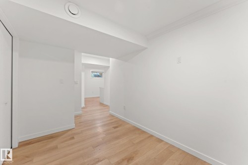 Light wood-finish flooring throughout, white walls, and a recessed ceiling vent - 10825 93 Street Nw, Edmonton, AB - Indoor Photo Showing Other Room