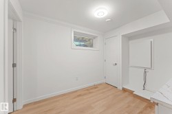 Wood-finish flooring, white walls, flush-mount ceiling light, and a window for natural light - 