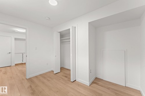 Light wood-finish flooring, recessed ceiling lighting, a built-in closet with shelves, and a white interior door - 10825 93 Street Nw, Edmonton, AB - Indoor Photo Showing Other Room