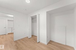 Light wood-finish flooring, recessed ceiling lighting, a built-in closet with shelves, and a white interior door - 
