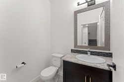 Vanity with a single basin, stone-finish countertop, and dark wood-finish cabinetry - 