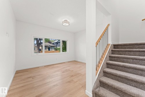 Wood-finish flooring, white walls, and a multi-pane window illuminate the space - 10825 93 Street Nw, Edmonton, AB - Indoor Photo Showing Other Room
