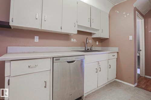 White cabinetry with chrome hardware, an undermount sink with a gooseneck faucet, a stainless steel dishwasher, and a laminate countertop - #45 1651 46 St Nw, Edmonton, AB - Indoor Photo Showing Kitchen
