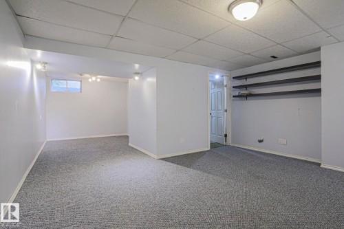 Recessed lighting fixtures, built-in shelving, window, wall-to-wall carpeting, and a drop ceiling - #45 1651 46 St Nw, Edmonton, AB - Indoor
