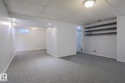 Recessed lighting fixtures, built-in shelving, window, wall-to-wall carpeting, and a drop ceiling - 