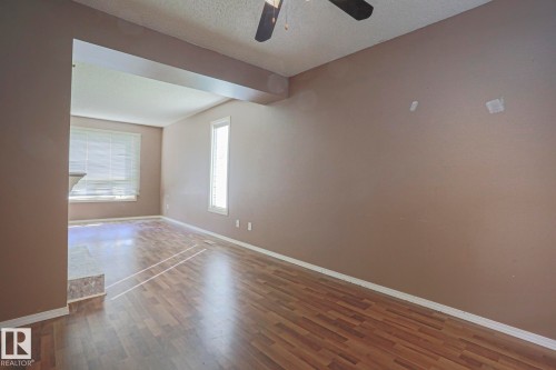 Wood-finish flooring throughout, ceiling fan, and multiple windows - #45 1651 46 St Nw, Edmonton, AB - Indoor Photo Showing Other Room