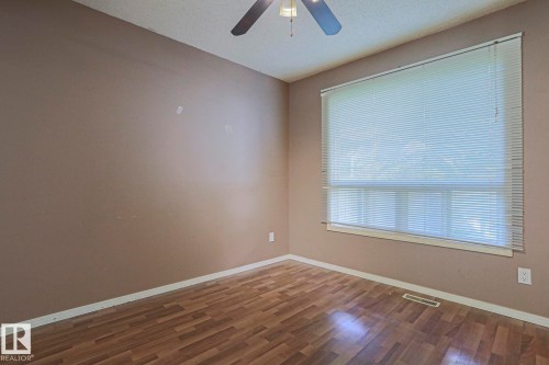 Wood-finish flooring with a ceiling fan and a window with blinds - #45 1651 46 St Nw, Edmonton, AB - Indoor Photo Showing Other Room