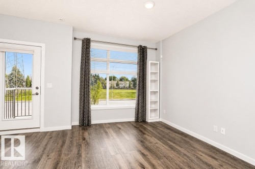 Wood-finish flooring, recessed lighting, and a built-in shelving unit - #6 215 Saddleback Rd Nw, Edmonton, AB - Indoor Photo Showing Other Room