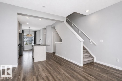 Wood-finish flooring throughout the main level - #6 215 Saddleback Rd Nw, Edmonton, AB - Indoor Photo Showing Other Room