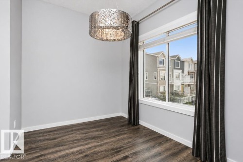 Wood-finish flooring, white trim, and light gray walls - #6 215 Saddleback Rd Nw, Edmonton, AB - Indoor Photo Showing Other Room