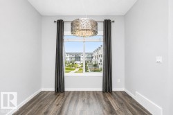 Bright window with white trim, wood-finish flooring, and a modern chandelier - 