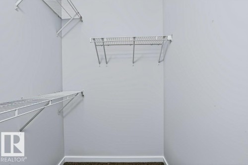 Walk-in closet featuring wire shelving and carpet flooring - #6 215 Saddleback Rd Nw, Edmonton, AB - Indoor With Storage