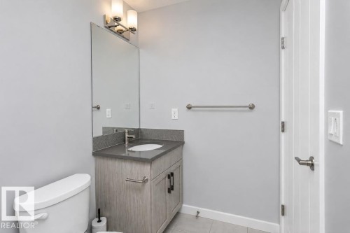 Vanity with a countertop, integrated sink, and modern hardware - #6 215 Saddleback Rd Nw, Edmonton, AB - Indoor Photo Showing Bathroom