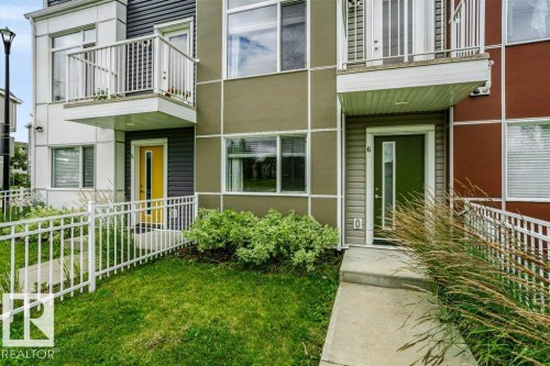 Modern exterior design with multi-tone siding, balcony with white railing, and concrete pathways - #6 215 Saddleback Rd Nw, Edmonton, AB - Outdoor