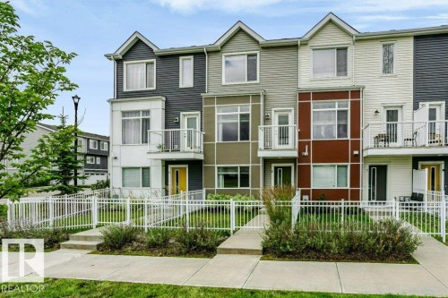 Modern townhome exterior featuring multi-toned siding, distinct gables, private balconies, and individual front entrances - #6 215 Saddleback Rd Nw, Edmonton, AB - Outdoor With Facade
