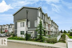 Multilevel townhome with grey siding, white trim, and individual balconies - 
