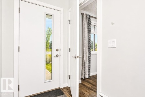 White entry door with a vertical glass insert - #6 215 Saddleback Rd Nw, Edmonton, AB - Indoor Photo Showing Other Room