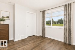 Wood-finish flooring, white trim, recessed lighting, white panel door, and a large window - 