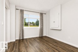 Wood-finish flooring, white walls, and a built-in storage cabinet - 