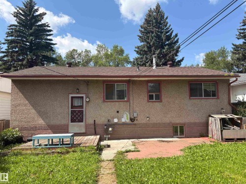Brick-clad ranch home featuring a covered entry with solid-core door, multi-pane windows with updated frames, and a rear deck with composite decking - 10845 140 Street Nw, Edmonton, AB - Outdoor With Exterior