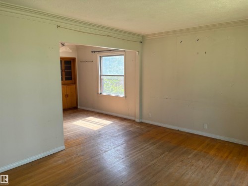 Bright corner room showcasing hardwood flooring, large windows with natural light, and clean walls ready for personalization - 10845 140 Street Nw, Edmonton, AB - Indoor Photo Showing Other Room