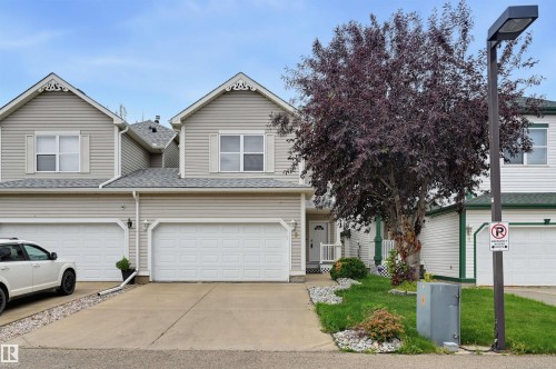 Siding exterior with decorative gables, attached garage, concrete driveway, and front entryway with a porch - #8 1920 Millwoods Rd E Nw, Edmonton, AB - Outdoor With Facade