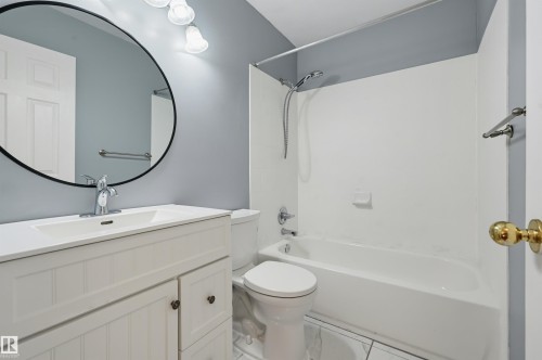 White vanity with beadboard paneling, integrated sink, and chrome faucet - #8 1920 Millwoods Rd E Nw, Edmonton, AB - Indoor Photo Showing Bathroom