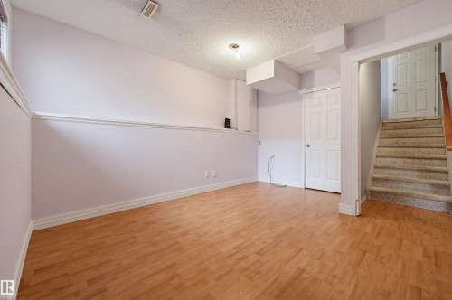 Wood-finish flooring, white trim, and a built-in closet - #8 1920 Millwoods Rd E Nw, Edmonton, AB - Indoor Photo Showing Other Room