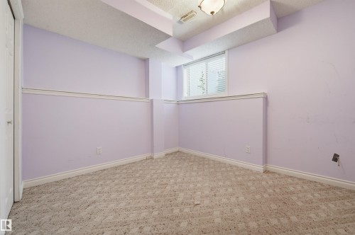 Carpeted room featuring a window with horizontal blinds, overhead lighting, and white trim - #8 1920 Millwoods Rd E Nw, Edmonton, AB - Indoor Photo Showing Other Room