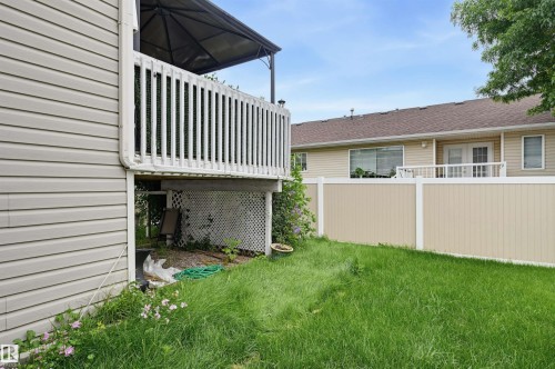 Elevated deck with white balusters, lattice skirting, and an overhead shade structure - #8 1920 Millwoods Rd E Nw, Edmonton, AB - Outdoor With Deck Patio Veranda With Exterior