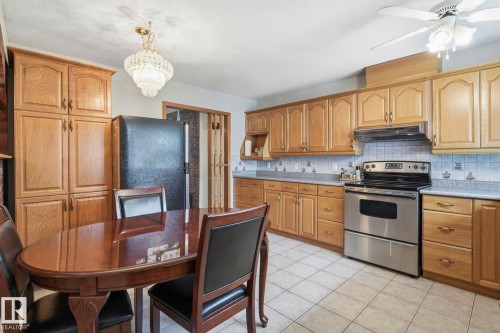 Recessed panel wood cabinetry, tile flooring, stainless steel range, and a decorative ceiling fan - 7 Graham Avenue, St. Albert, AB - Indoor Photo Showing Kitchen