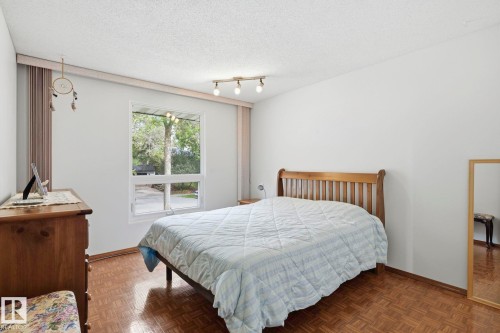 Window with exterior scenery, overhead track lighting, wood-finish flooring, and white walls - 7 Graham Avenue, St. Albert, AB - Indoor Photo Showing Bedroom
