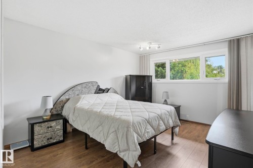 Wood-finish flooring, white walls, multiple windows, track lighting fixture - 7 Graham Avenue, St. Albert, AB - Indoor Photo Showing Bedroom