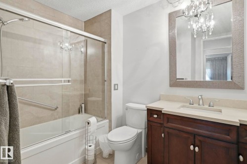 Vanity with a light-colored countertop, undermount sink, and dark wood-finish cabinetry - 7 Graham Avenue, St. Albert, AB - Indoor Photo Showing Bathroom
