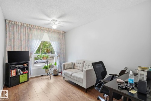 Spacious room with wood-finish flooring, a large window, a ceiling fan, and painted white walls - 7 Graham Avenue, St. Albert, AB - Indoor