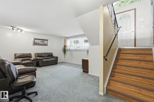 Carpeted living area with track lighting and a window featuring blinds - 7 Graham Avenue, St. Albert, AB - Indoor