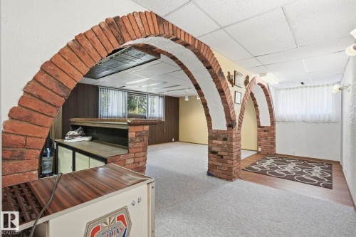 Brick archways, built-in bar, wood-finish paneling, and a drop ceiling - 7 Graham Avenue, St. Albert, AB - Indoor Photo Showing Other Room