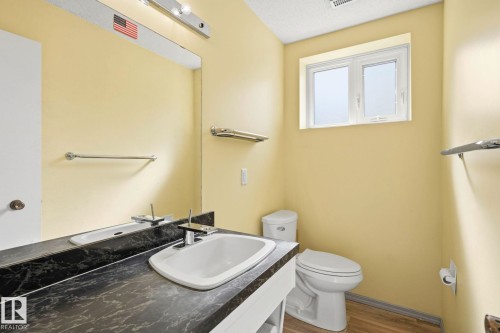 Single vanity with a dark, patterned countertop and integrated sink - 7 Graham Avenue, St. Albert, AB - Indoor Photo Showing Bathroom