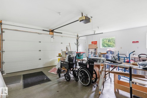Attached garage featuring a white overhead door, concrete flooring, and an automatic garage door opener - 7 Graham Avenue, St. Albert, AB - Indoor Photo Showing Garage