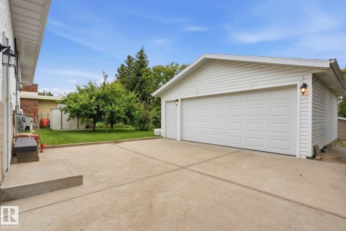 Detached garage with white siding, two garage doors, and exterior wall sconces - 7 Graham Avenue, St. Albert, AB - Outdoor With Exterior