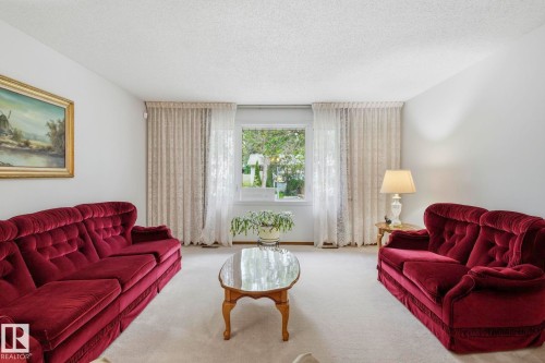 Wall-to-wall carpeting and a large window with sheer and solid drapes - 7 Graham Avenue, St. Albert, AB - Indoor Photo Showing Living Room