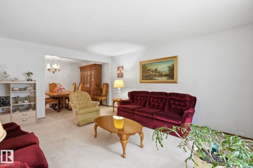 Carpeted living area with light-colored walls and a cased opening - 7 Graham Avenue, St. Albert, AB - Indoor Photo Showing Living Room