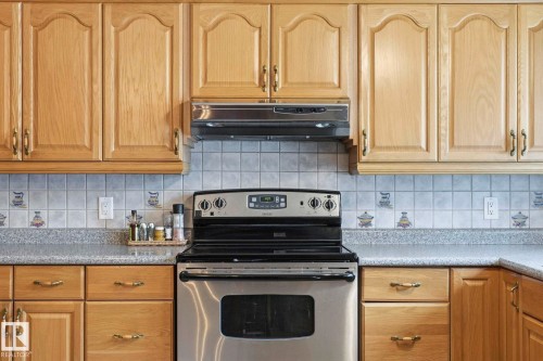Light wood-finish cabinetry, stainless steel range, and tile backsplash - 7 Graham Avenue, St. Albert, AB - Indoor Photo Showing Kitchen