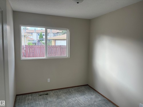 Neutral wall paint, textured ceiling, gray carpet flooring, and a white-framed window - 13831 23 Street Nw, Edmonton, AB - Indoor Photo Showing Other Room
